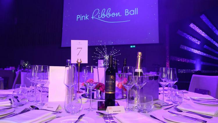 A table with plates, cutlery, bottles of wine and champagne at Breast Cancer Now's Pink Ribbon Ball