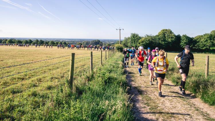 Fundraisers running across the countryside on a sunny summer's day