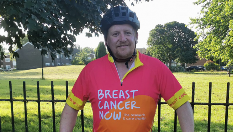 A Breast Cancer Now supporter standing by his bike