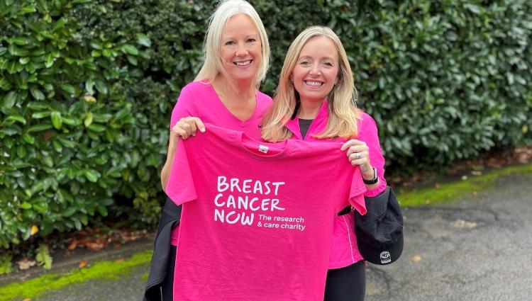 2 white women smiling and holding a pink Breast Cancer Now t-shirt