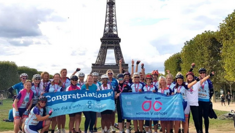Women V Cancer London to Paris - group of cyclists stand in front of the Eiffel Tower